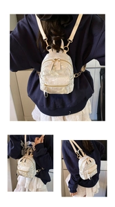 Détail d'un mini sac à dos en dentelle blanche avec broderie papillon et zips dorés