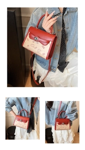 Detailed view of red and beige floral crossbody bag with cartoon bear print and top handle