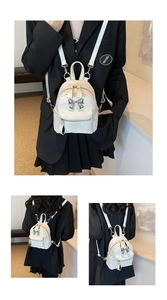 Détail d'un mini sac à dos blanc nacré avec nœud métallique et bretelles réglables