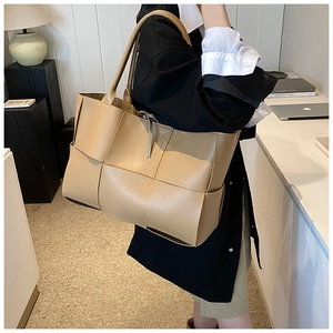 Side view of large khaki woven tote bag showing spacious capacity and PU leather straps
