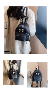 Détail du mini sac à dos en velours noir avec nœud argenté et compartiments zippés