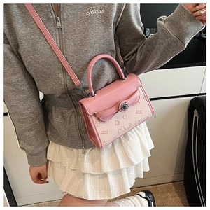 Detail of a pink and beige color-block crossbody bag with cartoon print and handle