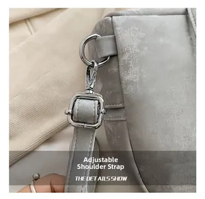Vue détaillée de la bandoulière réglable avec boucles argentées sur sac à dos gris
