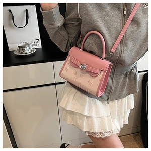 Detail of a pink and cream crossbody bag with cute cartoon embossing and metal lock