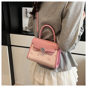 Detail of a pink crossbody bag with cartoon prints and silver metal swivel lock
