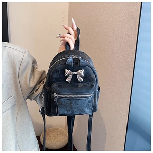 Vue détaillée du mini sac à dos noir avec nœud en métal argenté et bretelles réglables