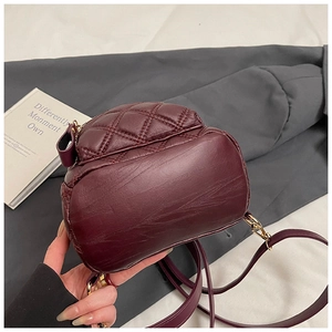 Dettaglio mini zaino in pelle trapuntata rosso vino con finiture metalliche dorate