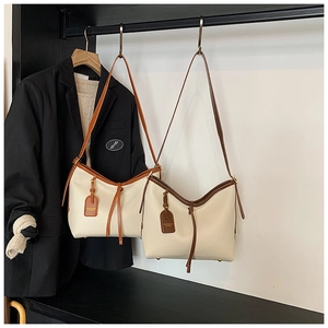 Détails de sacs fourre-tout crème avec bordures marron clair et foncé sur cintres