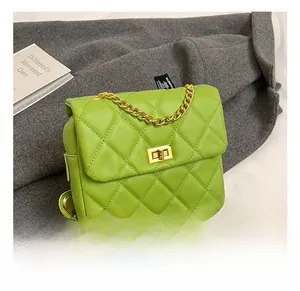 Close-up of bright green quilted shoulder bag with gold rotary lock and chain strap