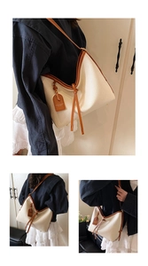 Détail du sac hobo blanc cassé avec bordure marron et gros plan sur la texture cuir