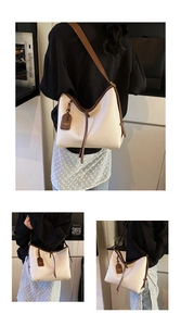 Détail du cabas blanc et marron montrant le cuir grainé litchi et l'étiquette de mode