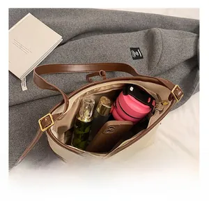 Vue détaillée de l'intérieur spacieux du sac fourre-tout beige montrant les essentiels