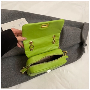 Detailed interior of neon green quilted chain bag with gold metal lock and zipper pocket