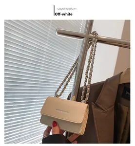 Dettaglio mini borsa bianco sporco con catena e logo metallico su supporto