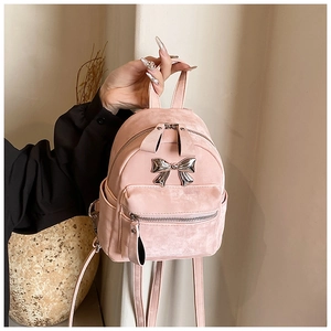 Gros plan détaillé du mini sac à dos rose avec nœud métallique argenté et tissu texturé