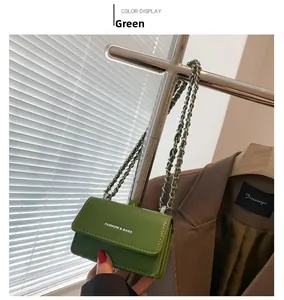 Dettaglio della mini borsa verde con catena e scritte bianche FASHION & BAGS stampate