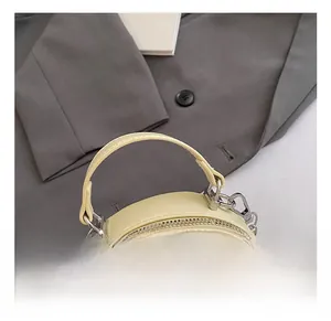 Detailed macro of a quilted light yellow circular handbag with silver metal hardware