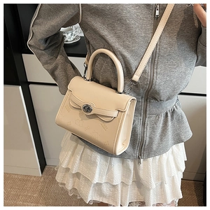 Detail of crossbody bag with embossed cartoon patterns and adjustable shoulder strap