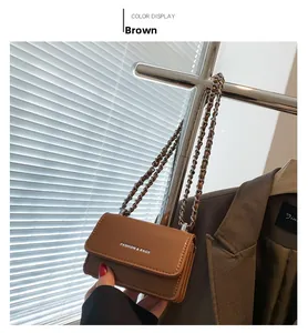 Dettaglio mini borsa marrone con catena e scritta FASHION & BAGS in rilievo