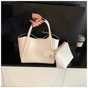 Detail of cream white leather bucket bag with elephant charm and inner pouch set