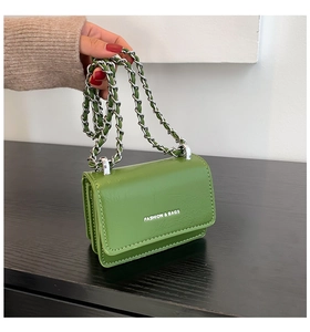 Dettaglio della mini borsa a tracolla verde con trama lucida e catena argento