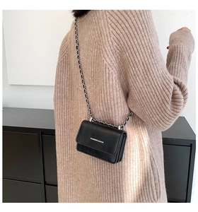 Mini borsa a tracolla nera con catena argentata indossata da una modella