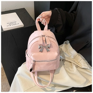 Détail d'un mini sac à dos rose avec un nœud en métal argenté et une texture mate