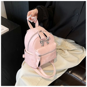 Détail d'un mini sac à dos rose avec noeud en métal argenté et bretelles réglables