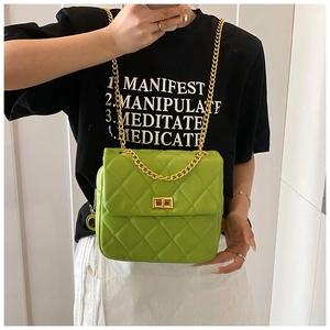 Detail of bright green quilted shoulder bag with gold chain and turn-lock closure