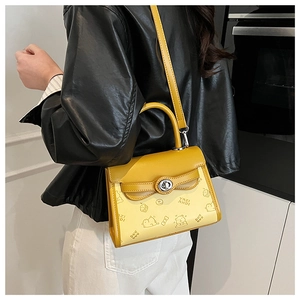 Detail of yellow rectangular crossbody bag with cartoon bear and donut prints
