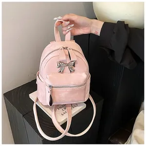 Vue détaillée du mini sac à dos rose avec texture velours et nœud en métal argenté