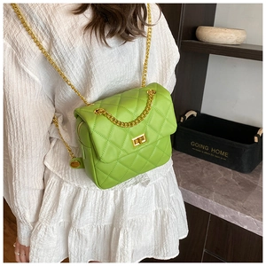 Detail of green quilted chain bag featuring a gold clasp and vibrant faux leather