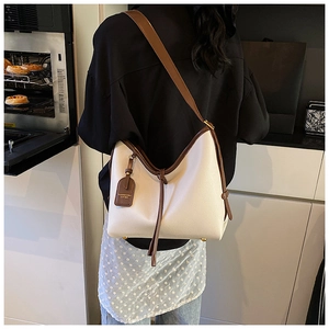 Détail d'un grand sac cabas blanc cassé avec garniture marron dans un décor de style de vie