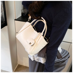 Detail of cream white lychee leather bucket bag with a cute elephant leather clasp
