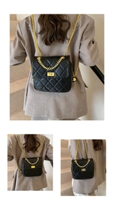 Detail of black quilted crossbody bag with gold chain strap on a chic staircase