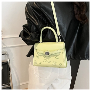 Detail view of light green embossed leather bag with silver buckle and crossbody strap