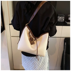 Détail du sac cabas en cuir grainé blanc avec bandoulières marron et étiquette mode