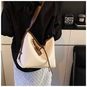 Détail du sac hobo en cuir grainé crème avec bordure marron et bandoulière réglable