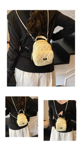 Detail of beige quilted mini backpack with metal twist lock and chain shoulder straps