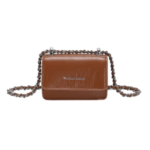 Dettaglio di una mini borsa in pelle lucida marrone con lettere argento e catena