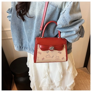 Detail of red and beige contrast bag with cartoon bear print and metal twist lock closure