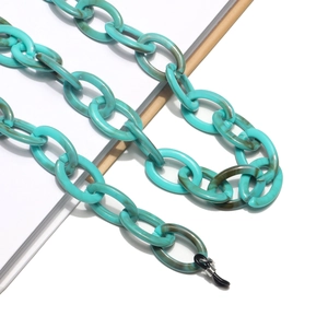 Macro detail of mint green resin chain with marble texture and black rubber loops