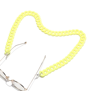 Macro detail of heart-shaped bright yellow acrylic chain link for minimalist eyeglasses