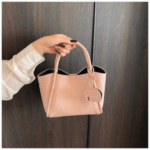 Close-up of pink lychee grain leather tote bag featuring a cute elephant charm