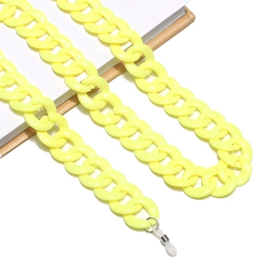 Detail of yellow acrylic link glasses chain with clear silicone anti-slip ends on a book