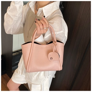 Detailed macro view of pink pebbled leather bucket bag with cute elephant charm