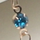 Macro detail of high-quality golden chain featuring vibrant blue rhinestone inlay
