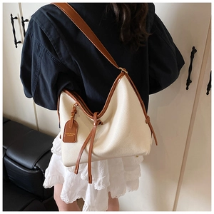 Détail du sac hobo crème avec cuir grainé et bandoulière réglable en cuir marron