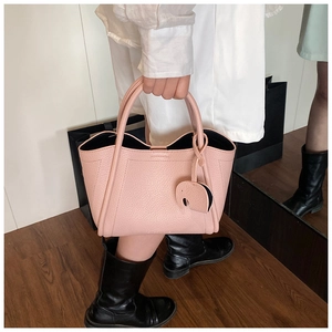 Pink lychee grain leather bucket bag detail with cute elephant charm and fabric lining