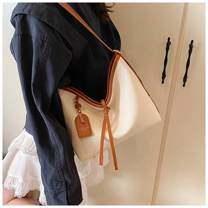 Vue détaillée du sac cabas en cuir litchi texturé avec franges élégantes et badge